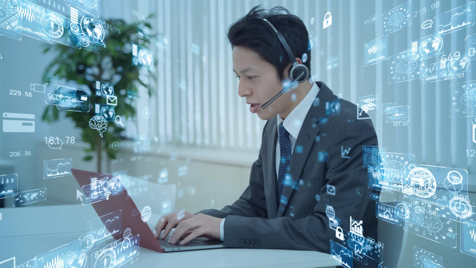 A person with a headset on a computer, surrounded by images of technology