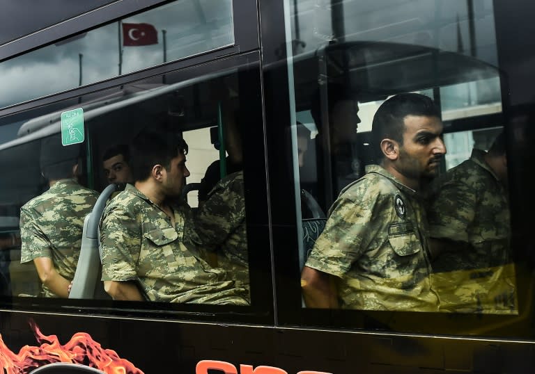 Detained Turkish soldiers who allegedly took part in a military coup arrive in a bus at the courthouse in Istanbul on July 20, 2016, following the military coup attempt of July 15