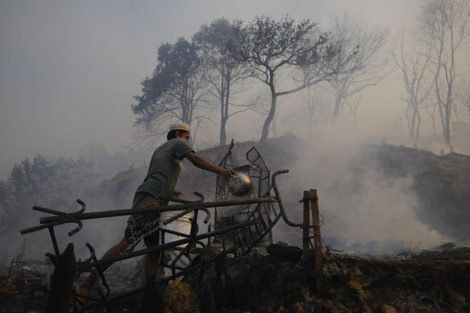 Rohingya refugees try to salvage their belongings after a major fire in their Balukhali camp at Ukhiya in Cox's Bazar district, Bangladesh, Sunday, March 5, 2023. A massive fire raced through a crammed camp of Rohingya refugees in southern Bangladesh on Sunday, leaving thousands homeless, a fire official and the United Nations said. (AP Photo/Mahmud Hossain Opu)