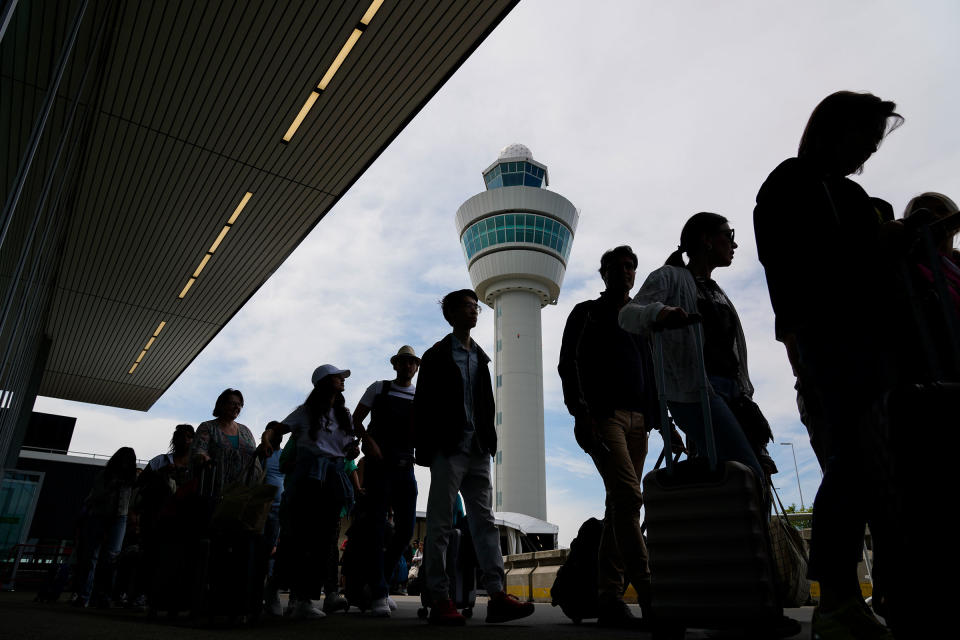 Travelers wait in long lines outside the terminal building to check in and board flights at Amsterdam's Schiphol Airport, on June 21, 2022.<span class="copyright">Peter Dejong—AP</span>