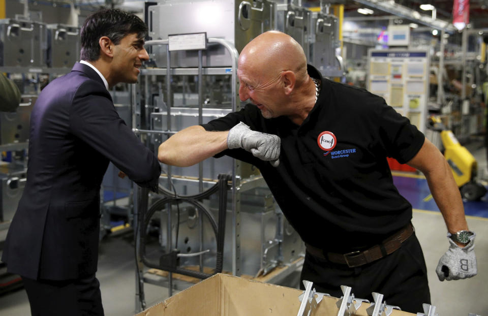 Britain's Chancellor of the Exchequer Rishi Sunak, left, greets an employee during a visit to Worcester Bosch factory to promote the initiative, Plan for Jobs, in Worcester, England, Thursday July 9, 2020. (Phil Noble/Pool via AP)