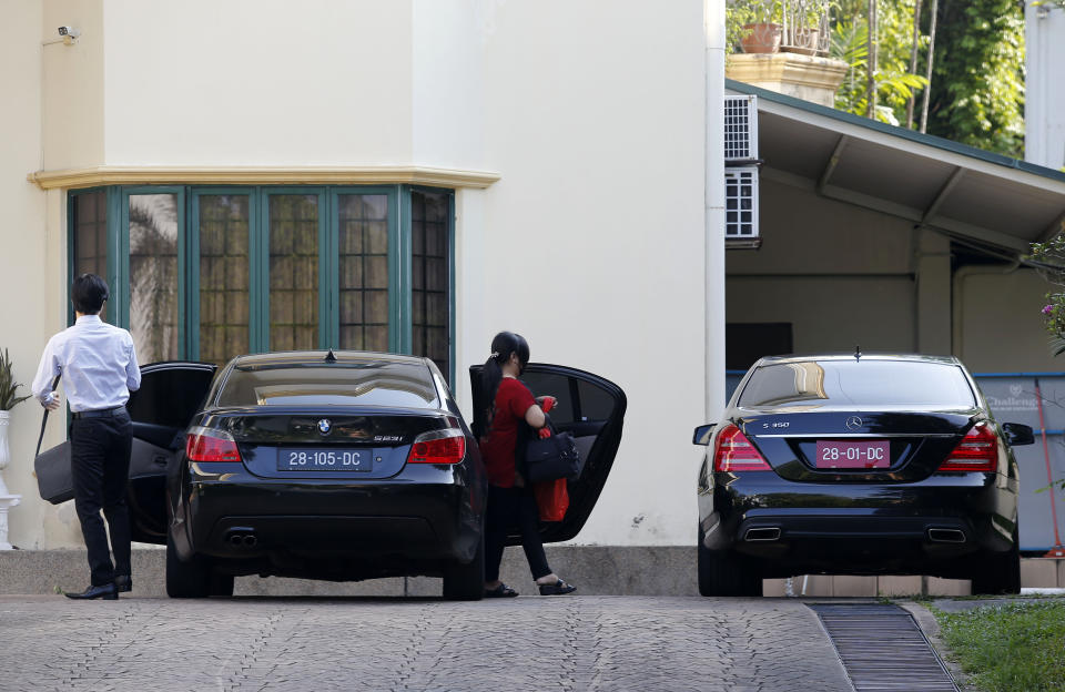 Unidentified persons get out of a car at the North Korean Embassy in Kuala Lumpur, Malaysia, Saturday, March 20, 2021. Malaysia said Friday it will order all North Korean diplomats to leave the country within 48 hours, an escalation of diplomat brawl over Malaysia's move to extradite a North Korean suspect to the United States for money laundering charges. (AP Photo/Lai Seng Sin)