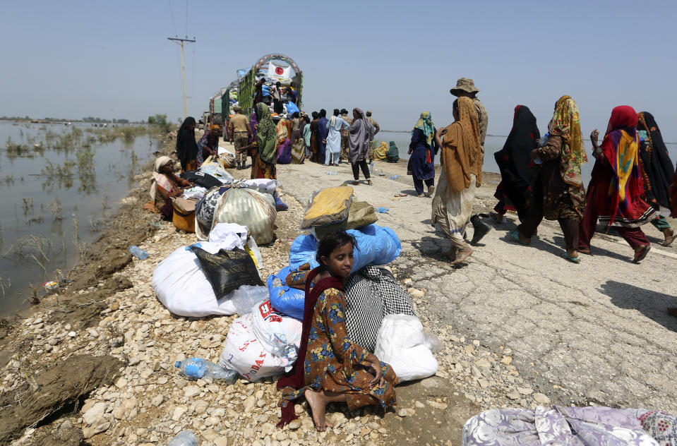 Victims of heavy flooding from monsoon rains rest with their relief aid from the Pakistani Army in the Qambar Shahdadkot district of Sindh Province, Pakistan, Friday, Sept. 9, 2022. U.N. Secretary-General Antonio Guterres appealed to the world for help for cash-strapped Pakistan after arriving in the country Friday to see the climate-induced devastation from months of deadly record floods. (AP Photo/Fareed Khan)