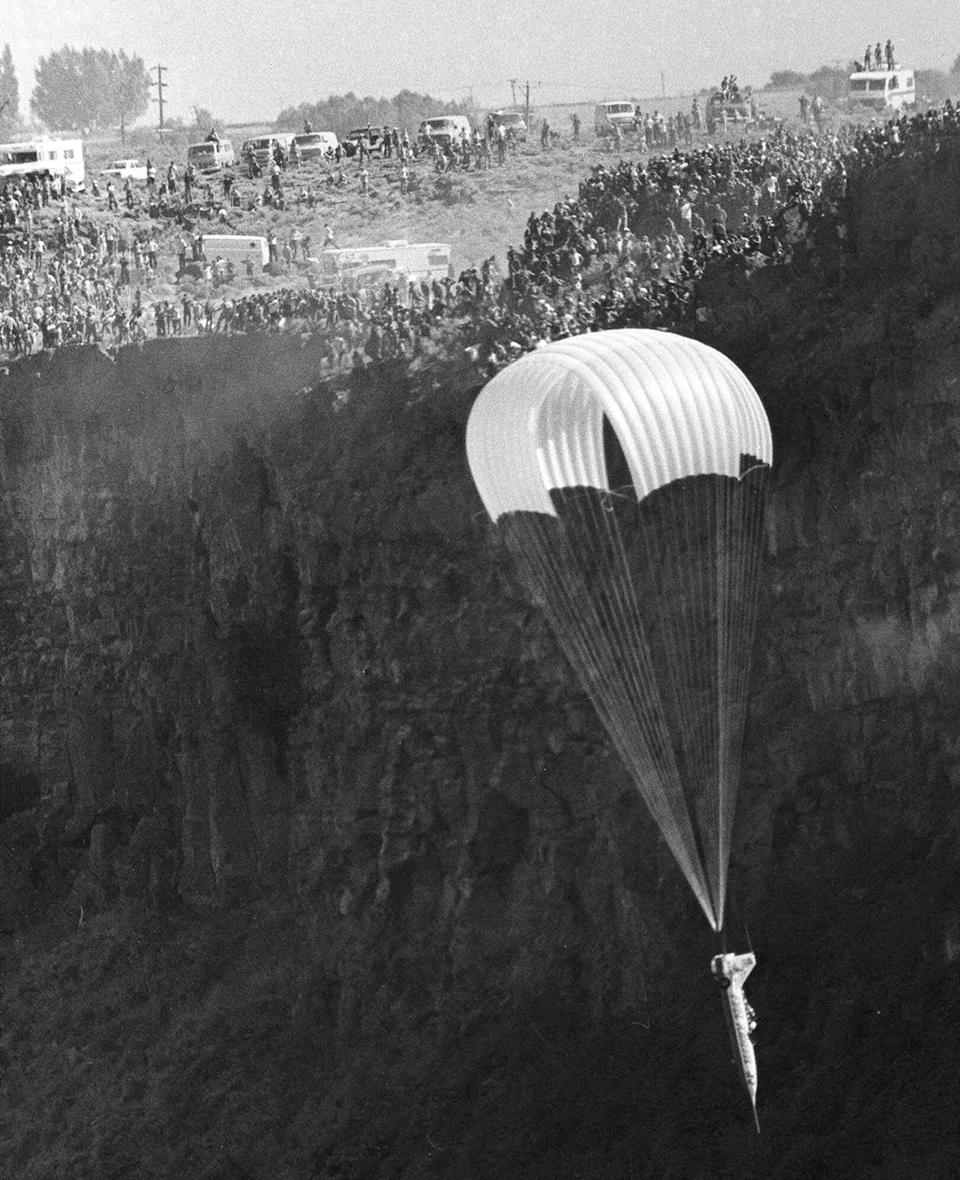 FILE - In this Sept. 8, 1974, file photo, Evel Knievel parachutes down in a rocket after an ill-fated attempt to soar across the Snake River Canyon in Twin Falls, Idaho. Evel Knievel’s son is on a collision course with the Walt Disney Co. and Pixar over a movie daredevil character named Duke Caboom. A federal trademark infringement lawsuit filed Tuesday, Sept. 22, 2020, in Las Vegas accuses the moviemaker of improperly basing the “Toy Story 4” character on Knievel. (AP Photo, File)