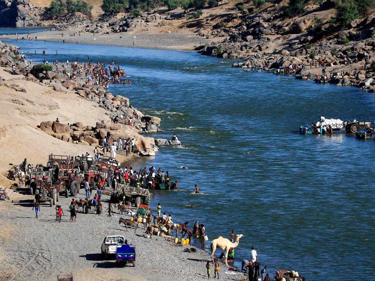 Ethiopian refugees gather on the banks of a border river with Sudan.  (AFP via Getty Images)