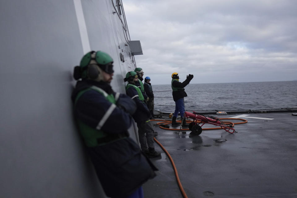 A mechanic steers a helicopter during a landing on the French navy frigate Normandie during a patrol in a Norwegian fjord, north of the Arctic circle, Thursday March 7, 2024. The French frigate is part of a NATO force conducting exercises in the seas, north of Norway, codenamed Steadfast Defender, which are the largest conducted by the 31 nation military alliance since the cold war. (AP Photo/Thibault Camus)