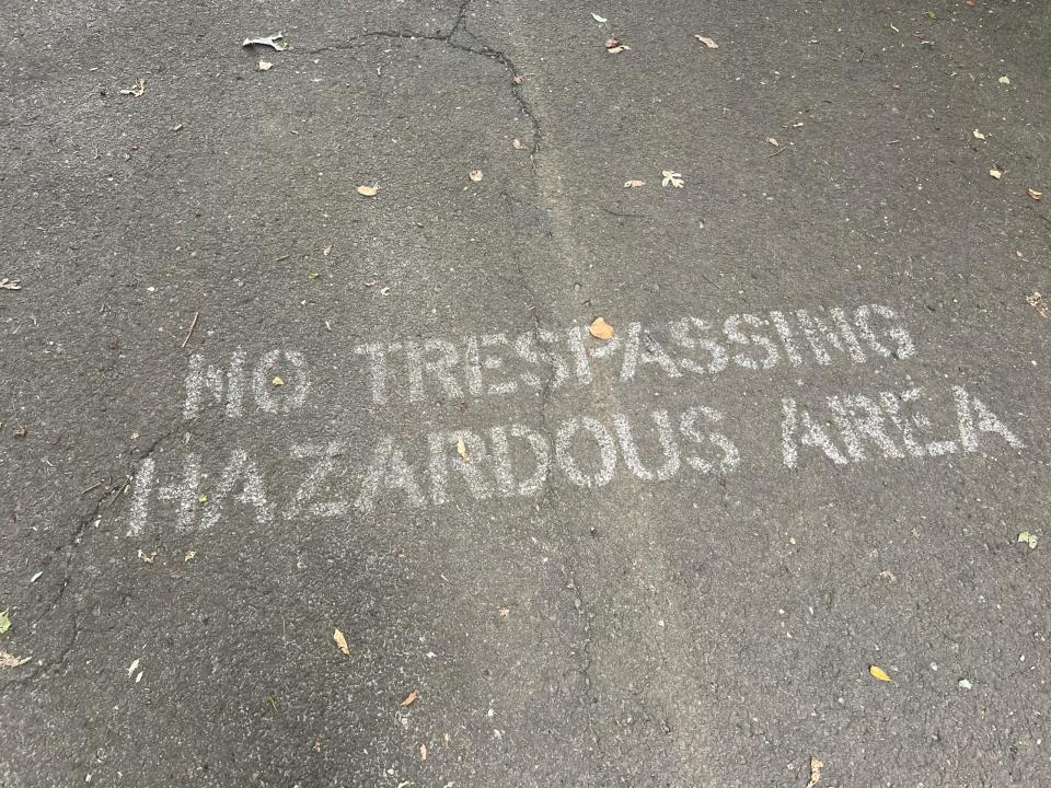 a sign on the ground that says no trespassing hazardous area