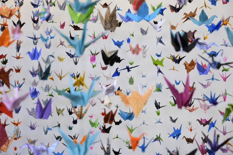 Origami paper cranes hang in the Matter Studio Gallery in Los Angeles during an exhibit for those who have died in the U.S. of COVID-19, on Tuesday, Aug. 11, 2020. Hundreds of origami now hang from the ceiling of Karla Funderburk’s Matter Studio with others sitting on tables and stacked in boxes waiting to be added to the sad reminder of the virus’ toll. (AP Photo/Richard Vogel)