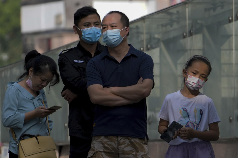 Residents wearing face masks wait in line to get their routine COVID-19 throat swabs at a coronavirus testing site in Beijing, Tuesday, Aug. 30, 2022. A Chinese think tank issued a rare public disagreement on Monday with the ruling Communist Party's severe "zero COVID" policy, saying curbs that shut down cities and disrupt trade, travel and industry must change to prevent an "economic stall." (AP Photo/Andy Wong)