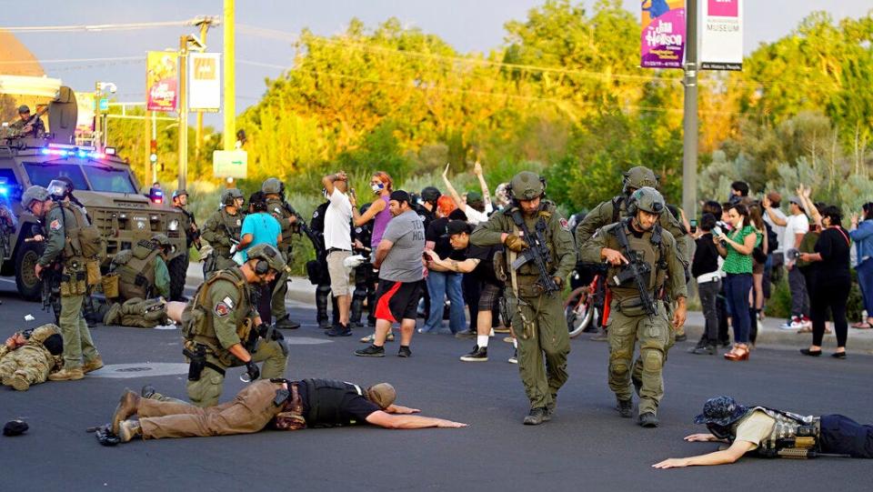 Albuquerque police detain members of the New Mexico Civil Guard, an armed civilian group, June 15, 2020, after a confrontation erupted between protesters and a group of armed men over a statue of Spanish conqueror Juan de Oñate.