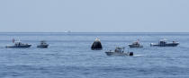 FILE - In this Sunday, Aug. 2, 2020, file photo, provided by NASA, support teams and curious recreational boaters arrive at the SpaceX Crew Dragon Endeavour spacecraft shortly after it landed with NASA astronauts Robert Behnken and Douglas Hurley on board in the Gulf of Mexico off the coast of Pensacola, Fla. The Demo-2 test flight for NASA's Commercial Crew Program was the first to deliver astronauts to the International Space Station and return them safely to Earth onboard a commercially built and operated spacecraft. Behnken and Hurley returned after spending 64 days in space. (Bill Ingalls/NASA via AP, File)