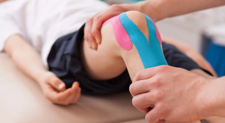 child with knee brace in a physical therapy session