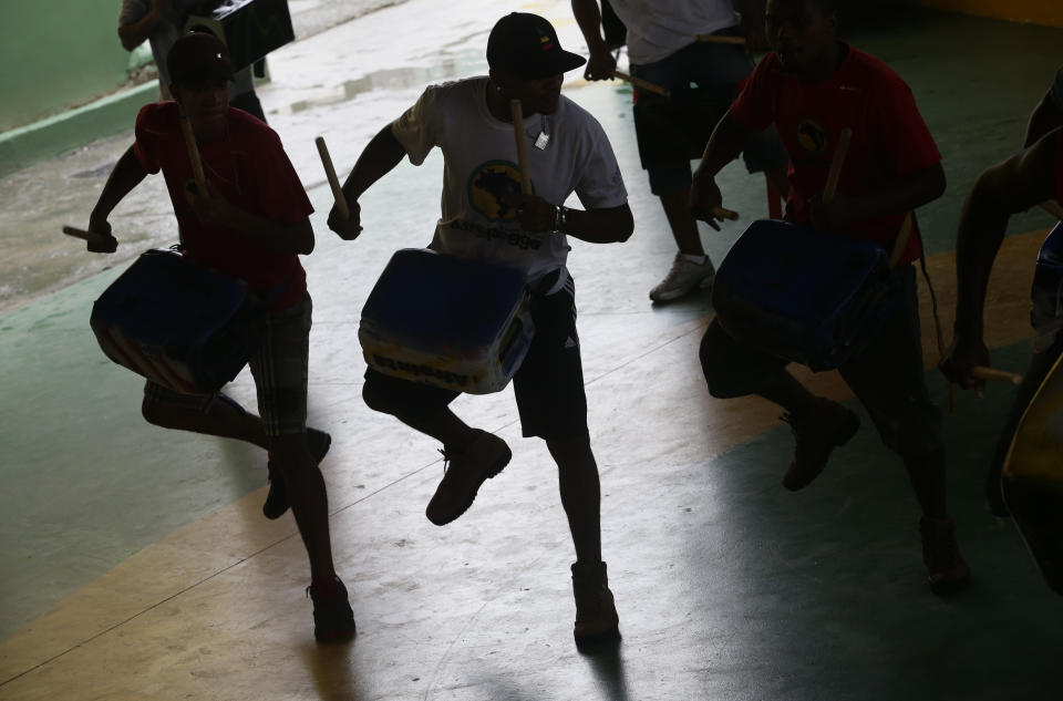 Musicians from Afro Reggae play drums during a presentation for London's Royal Opera House members in the Vigario Geral slum in Rio de Janeiro, Brazil, Saturday, March 2, 2013. This past week Royal Ballet dancers shared their knowledge and advice with promising artists during an education symposium between the company and the cultural arts center Afro Reggae. (AP Photo/Silvia Izquierdo)