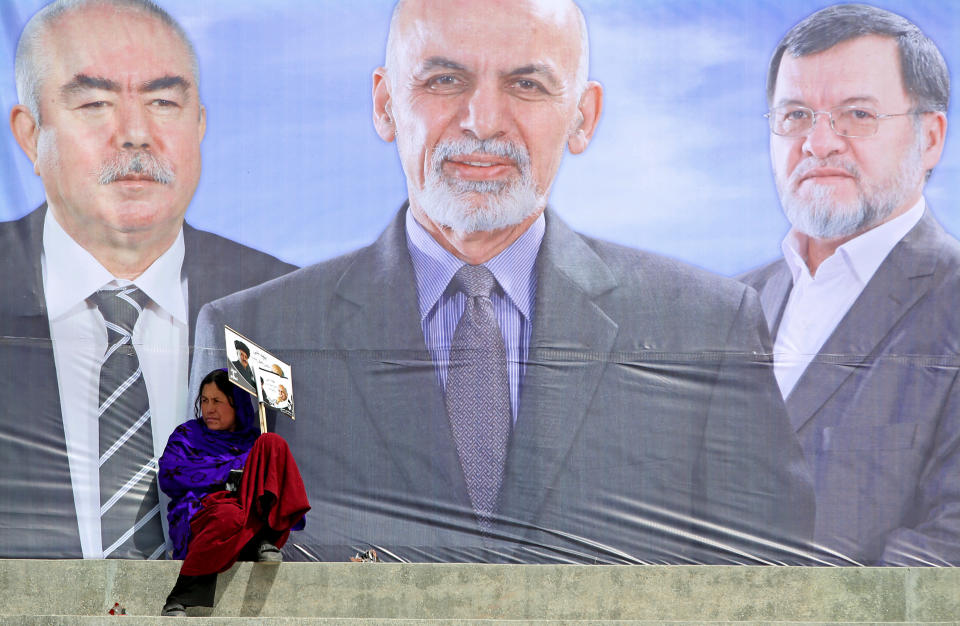 A female supporter of Afghan presidential candidate Ashraf Ghani Ahmadzai holds a poster during a campaign rally in Kabul, Afghanistan, Tuesday, April 1, 2014. Eight Afghan presidential candidates are campaigning for the third presidential election. Elections will take place on April 5, 2014. Writing on the poster reads, "we vote for Ashraf Ghani Ahmadzai." (AP Photo/Massoud Hossaini)