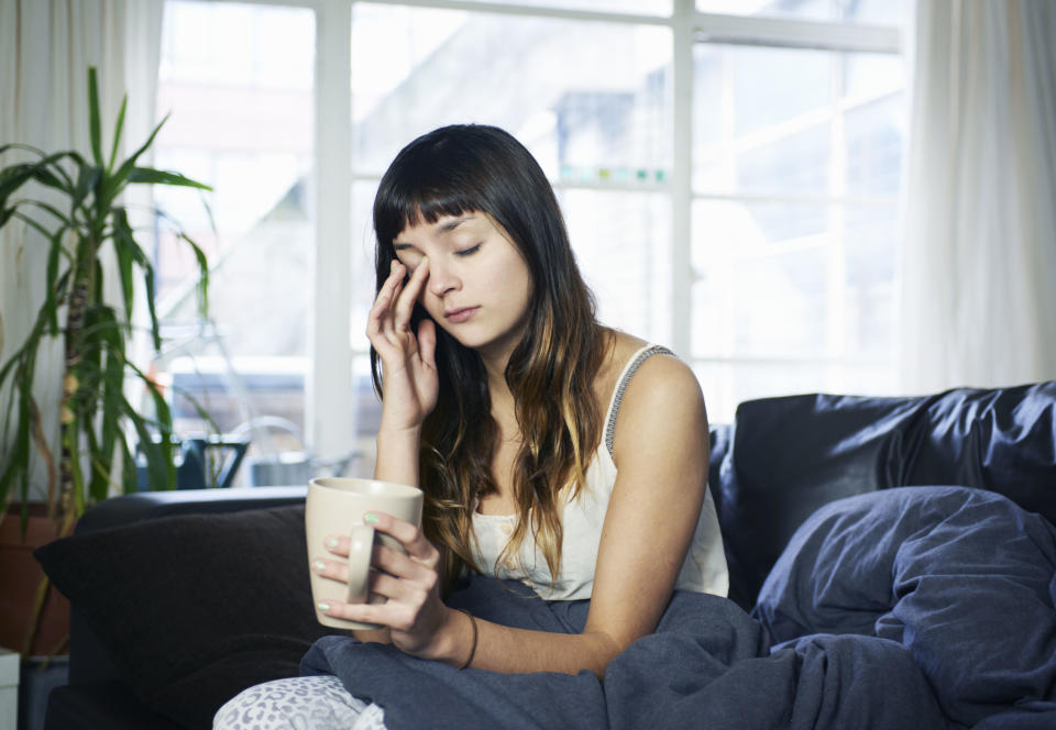 a person looking tired with their cup of coffee