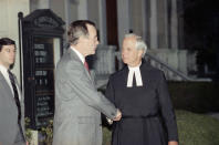 FILE - In this April 13, 1990 file photo, President George Bush is escorted by Rector John Harper, of St. John's Episcopal Church, following early morning Good Friday services in Washington. (AP Photo/Marcy Nighswander)