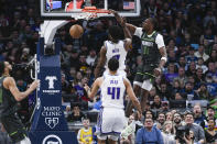 Minnesota Timberwolves center Naz Reid (11) dunks in front of Sacramento Kings forward Chimezie Metu and center Trey Lyles (41) during the second half of an NBA basketball game Saturday, Jan. 28, 2023, in Minneapolis. The Timberwolves won 117-110. (AP Photo/Craig Lassig)