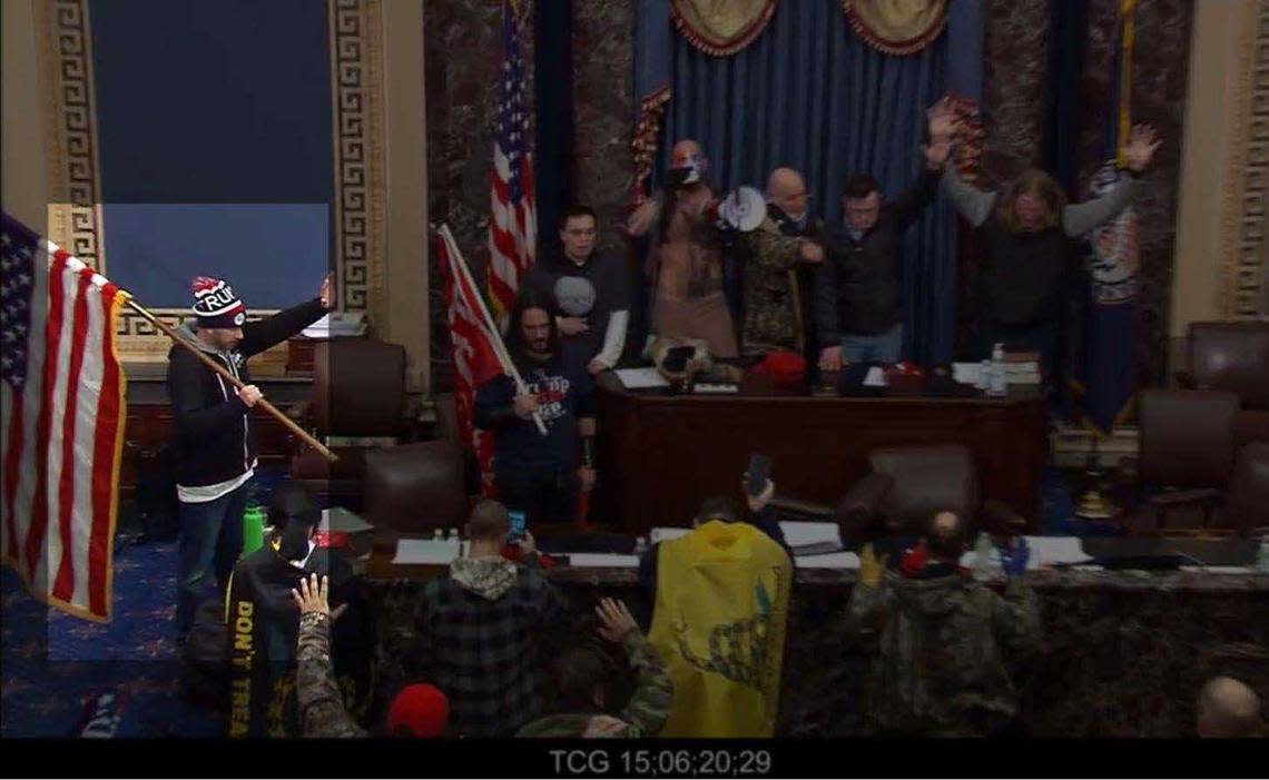 In an image take from video and highlighted by prosecutors, Tommy Allen is seen holding an American flag on the floor of the U.S. Senate chambers during a riot at the U.S. Capitol on Jan. 6, 2021. The Rocklin man was sentenced Thursday to 21 months in prison.