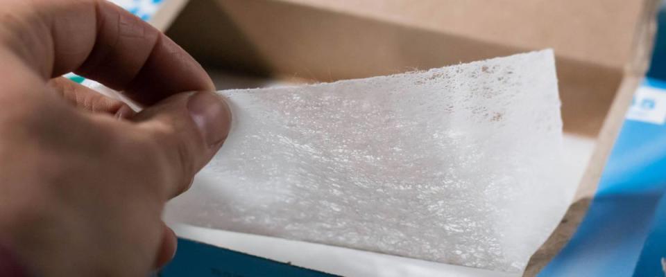 Cumberland, Rhode Island/ USA- March 31, 2019 a box of laundry dryer sheets being placed on top of a dryer with the rest of the laundry cleaning products.