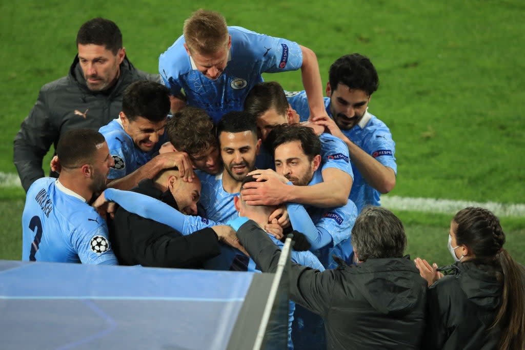 <p>Foden’s teammates and manager mob him after City’s second goal</p> (AFP via Getty Images)