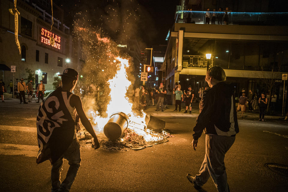 Protesters set a dumpster on fire after a shooting on Thursday, June 3, 2021 in Minneapolis. Crowds vandalized buildings and stole from businesses in Minneapolis’ Uptown neighborhood after officials said a man wanted for illegally possessing a gun was fatally shot by authorities. (Richard.Tsong-Taatari/Star Tribune via AP)