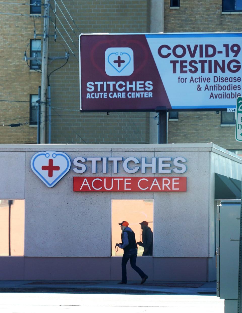 A woman walks past an urgent-care clinic offering coronavirus tests in downtown Cheyenne, Wyoming, on Nov. 16, 2020.