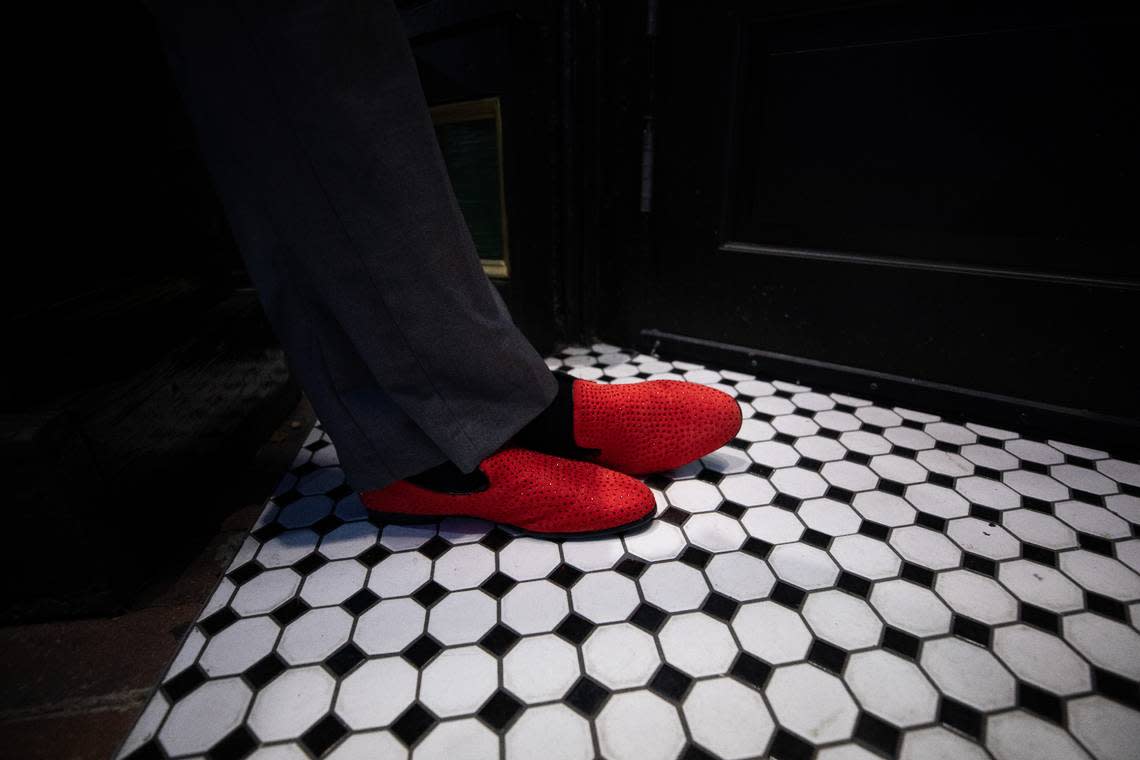 Carl Wells, a doorman at Peggy’s Whiskey & Cocktails, greets visitors with bright red shoes on the evening of Friday, July 21, 2023.