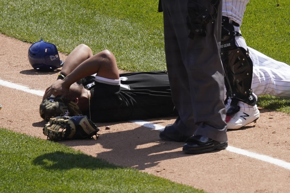 Chicago White Sox's Jose Abreu holds his head after colliding along the first base line with Kansas City Royals' Hunter Dozier in the second inning of the first game of a baseball doubleheader Friday, May 14, 2021, in Chicago. (AP Photo/Charles Rex Arbogast)