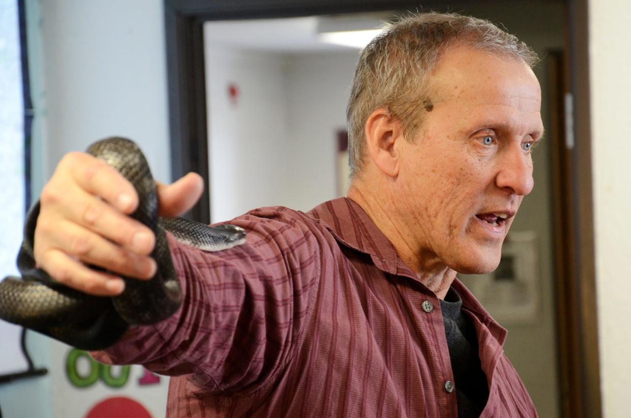 Jim McGrath holds a black rat snake at Concord Academy Petoskey during his Snakes Alive program. The program was brought to the school in partnership with the Straits Area Audubon Society.