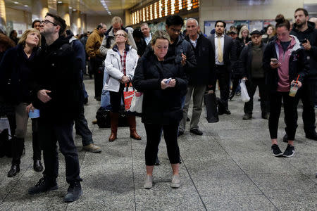 People stand in Pennsylvania Station waiting for trains in the Manhattan borough of New York City, New York, U.S., March 16, 2018. REUTERS/Shannon Stapleton