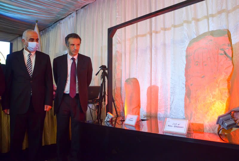 Nayef al Fayez, Jordanian Tourism Minister stands next the two statues uncovered by archaeologists in the southeastern Jordanian desert during a news conference in Amman