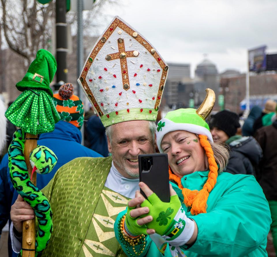 Kevin Malone, 56, left, poses for a selfie during the St. Patrick's Parade along Michigan Avenue in Detroit's Corktown on Sunday, March 13, 2022.