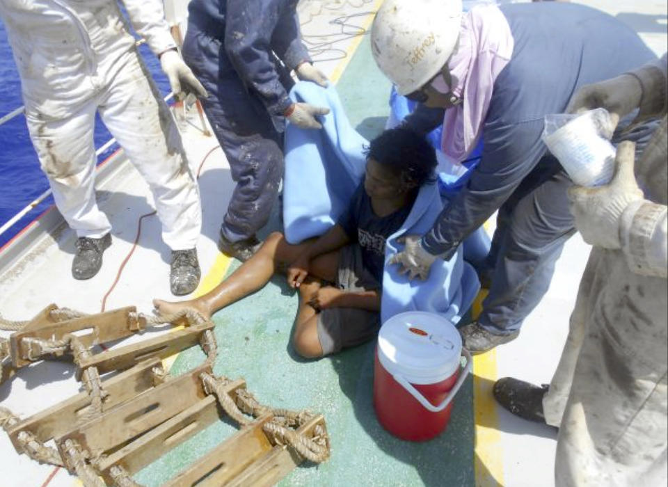 In this undated photo released by Indonesian Consulate General in Osaka, 18-year-old Aldi Novel Adilang sits on the deck of a Panamanian-flagged vessel, MV Arpeggio after being rescued in the waters near Guam. The Indonesian teenager has survived about 7 weeks adrift at sea after the floating wooden fish trap he was employed to mind slipped its moorings. Aldi's parents and the Indonesian Consulate in Osaka, Japan, said he was rescued by MV Arpeggio off Guam on Aug. 31 and returned to Indonesia earlier this month. (Indonesian Consulate General in Osaka via AP)