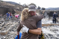 <p>Craig Bolleson hugs his friend in his burned out home, Monday, Sept. 4, 2017, in the Sunland-Tujunga section of Los Angeles. (Photo: Ringo H.W. Chiu/AP) </p>