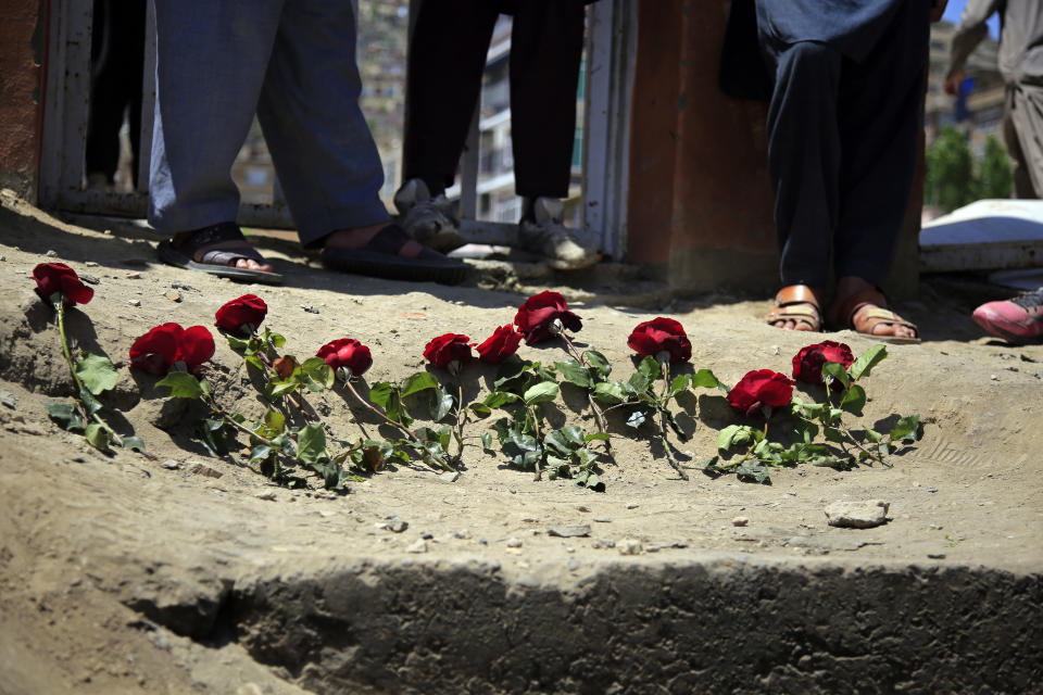 People puts flowers outside a school after a deadly attack on Saturday, in Kabul, Afghanistan, Sunday, May 9, 2021. The Interior Ministry said Sunday that the death toll in the horrific bombing at the entrance to the girls' school in the Afghan capital has soared to some 50 people, many of them pupils between 11 and 15 years old, and the number of wounded in Saturday's attack has also climbed to more than 100. (AP Photo/Mariam Zuhaib)