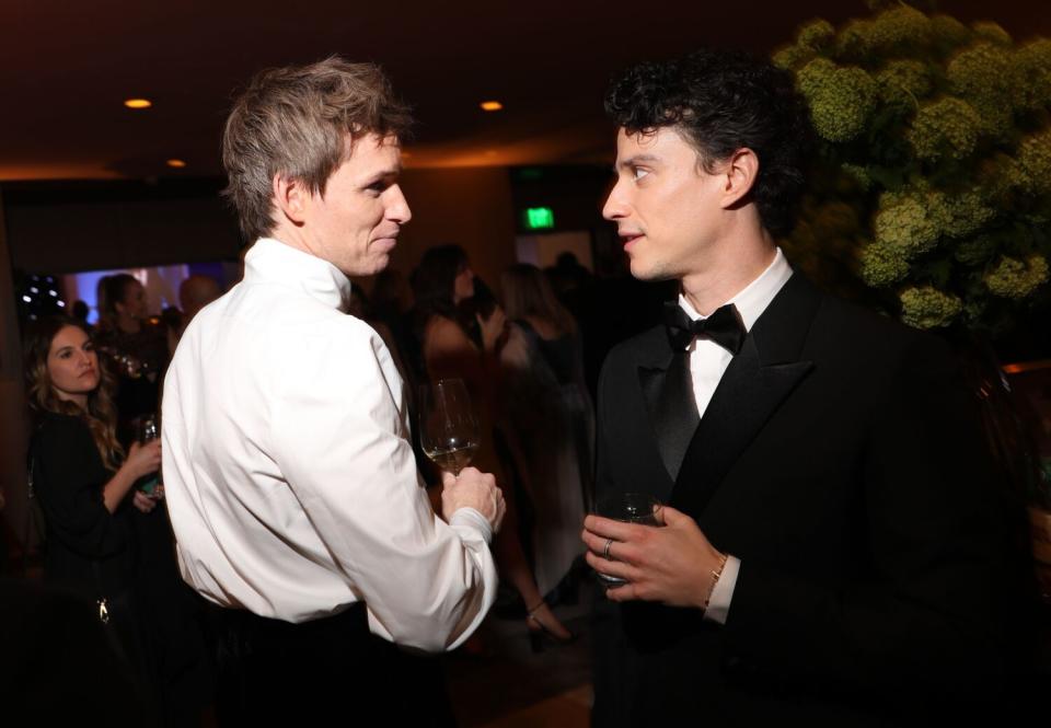 two young men in tuxes talk to each other