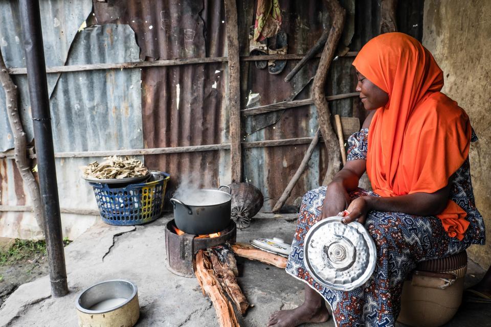 Habiba prepares a meal with food she bought at the market with a Mercy Corps food voucher. She was displaced by Boko Haram and takes care of three children.