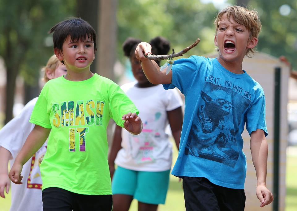 Caleb Miller, 9, right, carries a stick with a cicada on it as he and other children play at Monnish Park on an outing with Tuscaloosa Parks and Recreation Authority's summer day camp with the Phelps Center, in Tuscaloosa, Ala. on Tuesday, Aug. 11, 2015. Staff photo | Erin Nelson