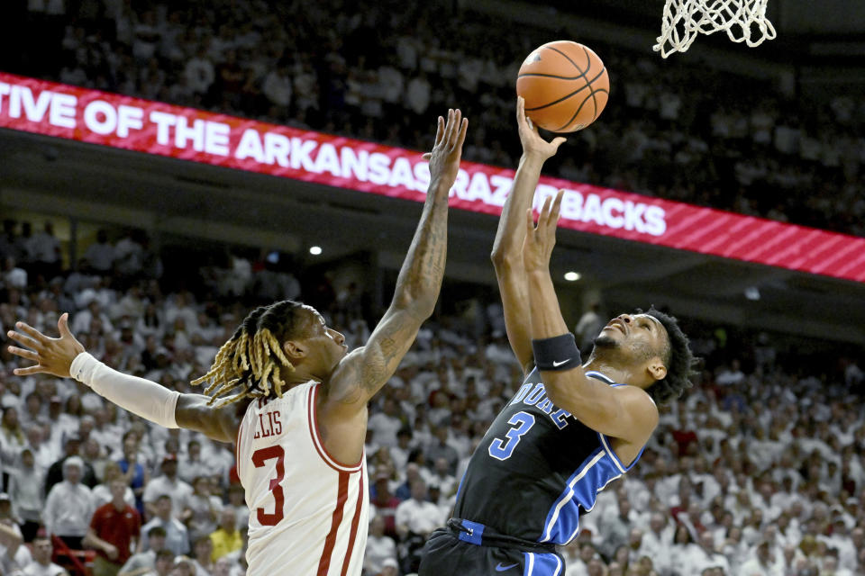 Duke guard Jeremy Roach, right, tries to shoot over Arkansas guard El Ellis, left, during the first half of an NCAA college basketball game Wednesday, Nov. 29, 2023, in Fayetteville, Ark. (AP Photo/Michael Woods)