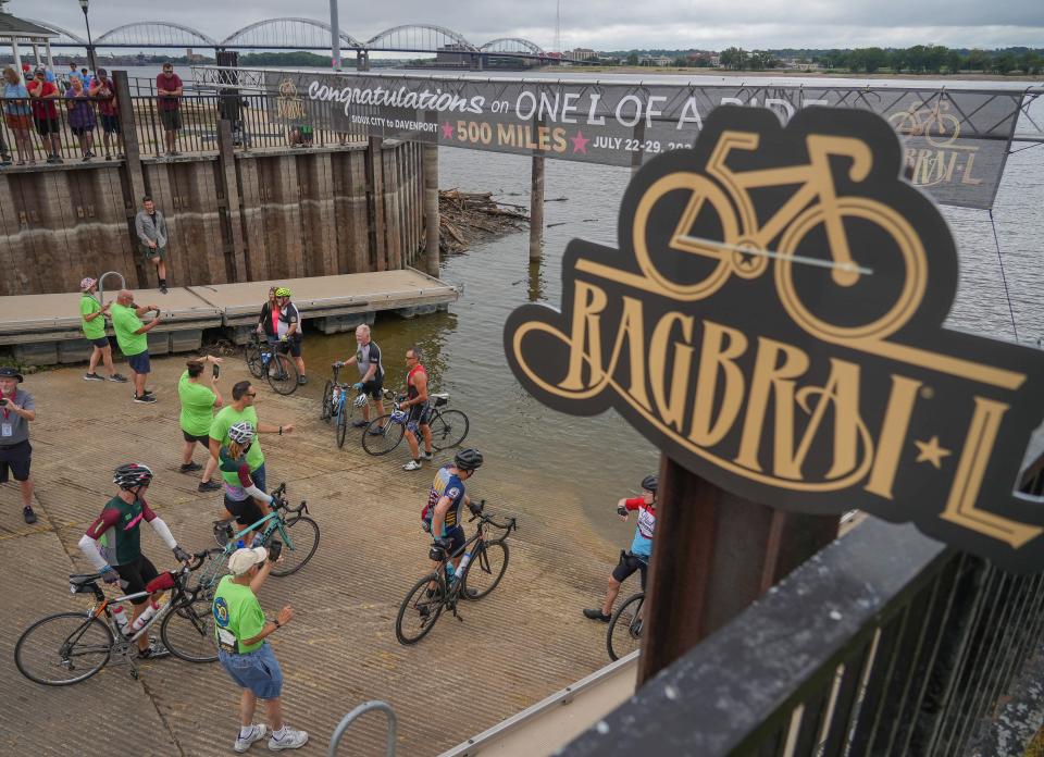 Cyclists dip their tires in the Mississippi River in Davenport as the 50th anniversary edition of RAGBRAI comes to a close Saturday.