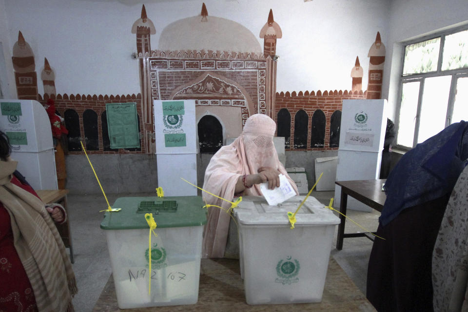 A woman casts her vote at a polling station during the country's parliamentary elections in Peshawar, Pakistan, Thursday, Feb. 8, 2024. Pakistanis lined braved cold winter weather and the threat of violence to vote for a new parliament Thursday, a day after twin bombings claimed at least 30 lives in the worst election-related violence ahead of the contested elections. (AP Photo/Muhammad Sajjad)