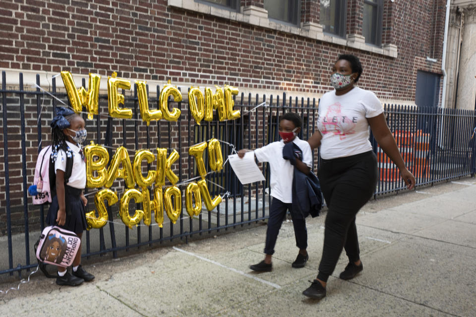 A "Welcome Back to School" hangs on a fence at Brooklyn's PS 245 elementary school as children arrive for the first day of class, Monday, Sept. 13, 2021, in New York. Classroom doors are swinging open for about a million New York City public school students in the nation's largest experiment of in-person learning during the coronavirus pandemic. (AP Photo/Mark Lennihan)