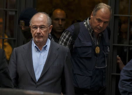 Rodrigo Rato (L), former People's Party minister and former managing director of the International Monetary Fund, is lead by police as they leave his residence after an inspection in Madrid, April 16, 2015. REUTERS/Sergio Perez