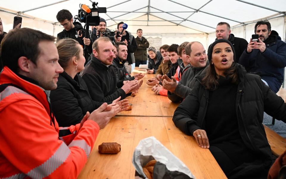 Karine Le Marchand speaks with farmers as she visits a road blockage held by farmers on the A4 highway near Jossigny, east of Paris