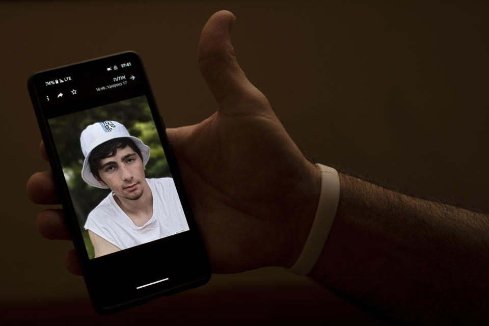Nir Shani, a 46-year old physical therapist from Kibbutz Be'eri, shows a photo of Amit, his 16-year-old son held hostage in Gaza, in Ein Bokek, Israel, Sunday, Israel, Oct. 22, 2023. Two weeks after Hamas militants gunned down 10 percent of their community, torturing scores of people and kidnapping many back to Gaza, the Israeli government has relocated half the kibbutz to the upscale David Resort, a hotel-turned-refugee camp. (AP Photo/Maya Alleruzzo)