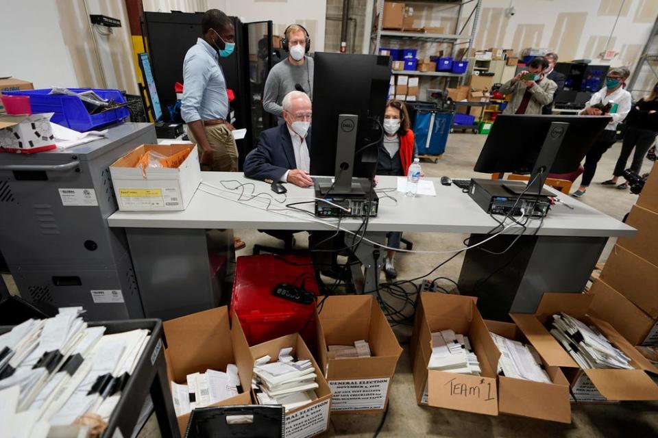 Democratic and Republican representatives review absentee ballots at the Fulton County Elections Preparation Center in Atlanta on Wednesday, Nov. 4, 2020.