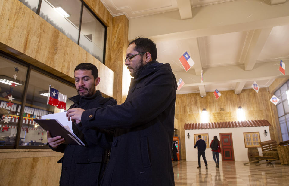 Los líderes de la organización Movimiento de Integración y Liberación Homosexual de Chile, Ramón Gómez, a la izquierda, y Gonzalo Velásquez, se preparan para presentar una acusación contra el gobierno por violar un acuerdo de matrimonio entre personas del mismo sexo de 2016 con la Comisión Interamericana de Derechos Humanos en la sede del Contralor en Santiago de Chile, el martes 10 de septiembre de 2019. (AP Foto / Esteban Felix)