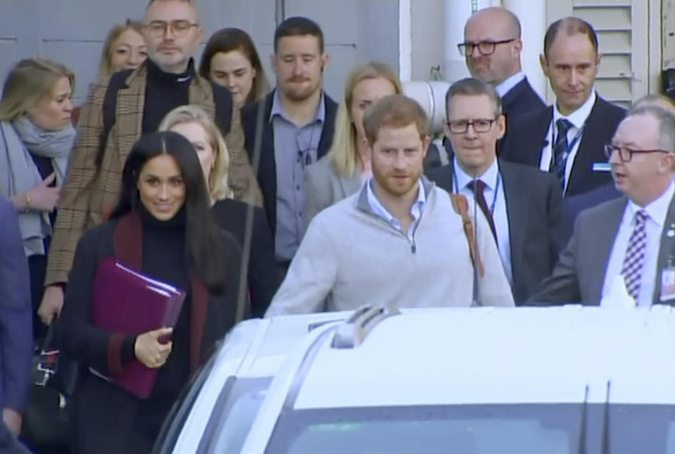 En esta imagen tomada de un video, el príncipe Enrique de Inglaterra y su esposa Meghan Markle, duquesa de Sussex, caminan a un auto en un aeropuerto en Sydney, el lunes 15 de octubre del 2018. La pareja real llegó a Sydney el lunes para una visita de 16 días por Australia, Fiyi, Tonga y Nueva Zelanda. El Palacio de Kensington anunció el mismo día que Enrique y Meghan esperan su primer bebé para la primavera boreal. (Australian Pool vía AP)