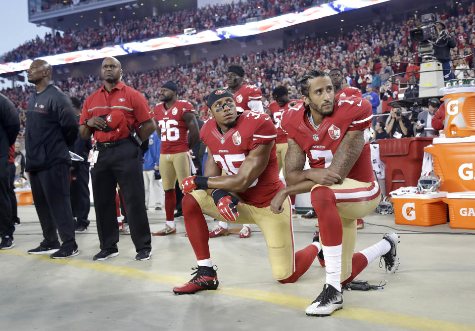 Eric Reid (35) and Colin Kaepernick (7) kneel during the national anthem before a game in 2016. (AP)