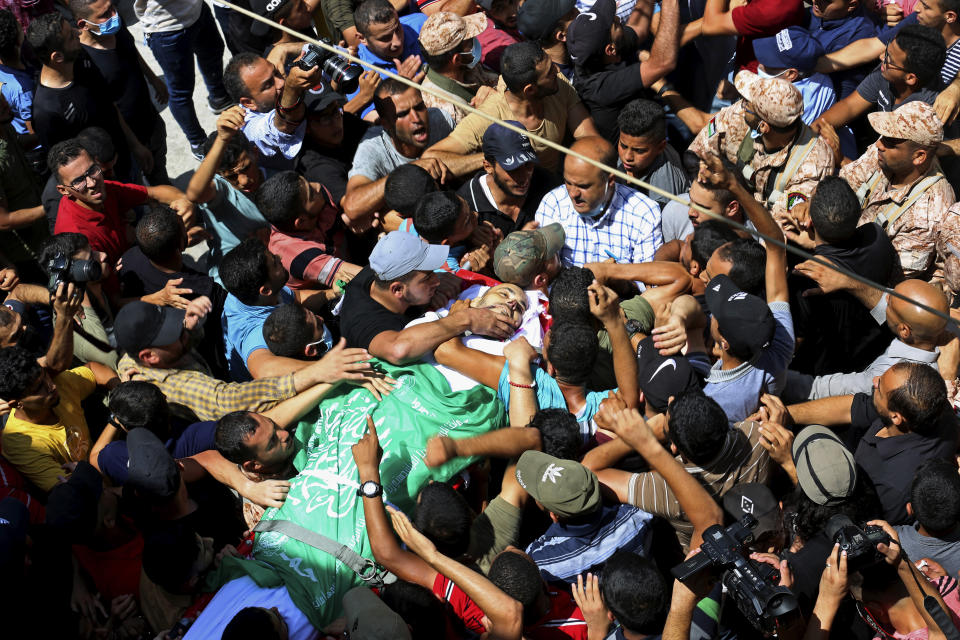 Palestinian mourners carry the body of Osama Dueij, 32, who was shot in the leg on Saturday during a violent demonstration on the northern border between Gaza and Israel, during his funeral in front of his family house in Jebaliya refugee camp, northern Gaza Strip, Wednesday, Aug. 25, 2021. (AP Photo/Adel Hana)